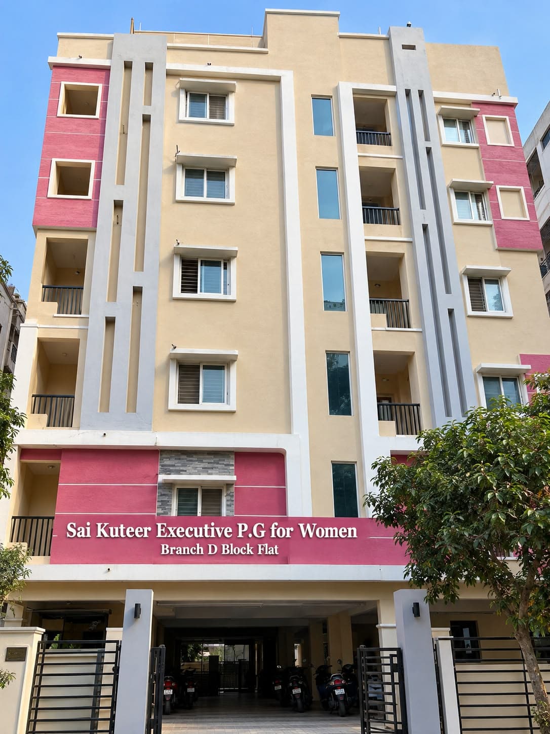 Patrika Nagar Block B, a cream and pink building with a Sai Kuteer name board above its gated entrance and parking